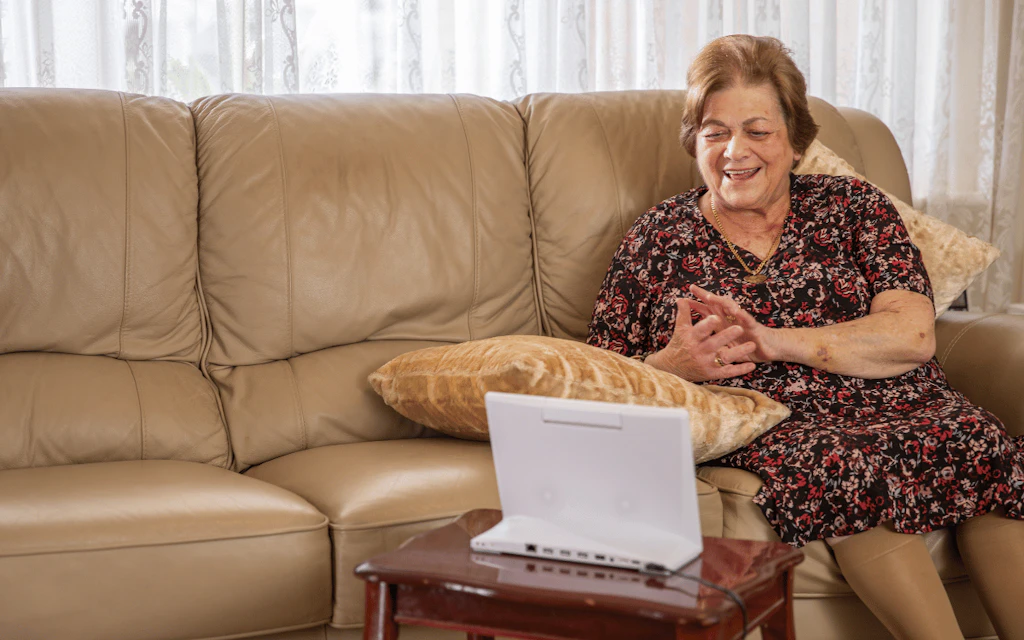 Woman smiling at an assistive technology device